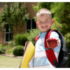 Decoratieve foto van een vrolijk lachende jongen die een appel toont