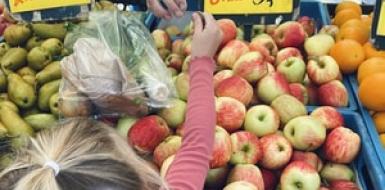 Decoratieve foto van een leerling die op de markt betaalt voor groente en fruit